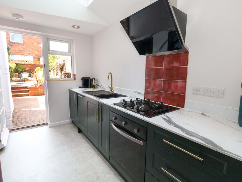 A kitchen with cabinets and a gas stove at Otter Cottage in Weymouth
