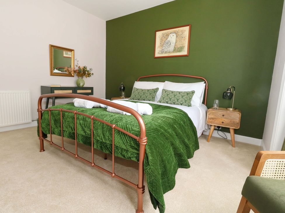 A bedroom with a bed and a nightstand at Otter Cottage in Weymouth