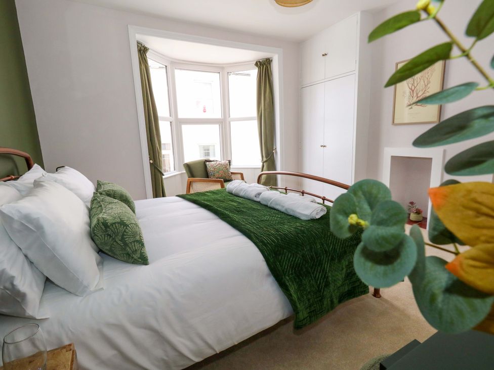 A bedroom with bed and window at Otter Cottage in Weymouth