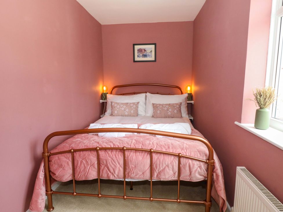 A bedroom with a bed and lamp at Otter Cottage in Weymouth