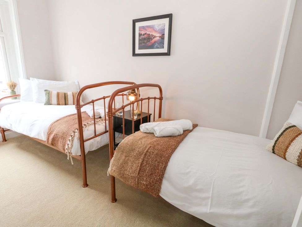 A bedroom with twin beds and a nightstand at Otter Cottage in Weymouth