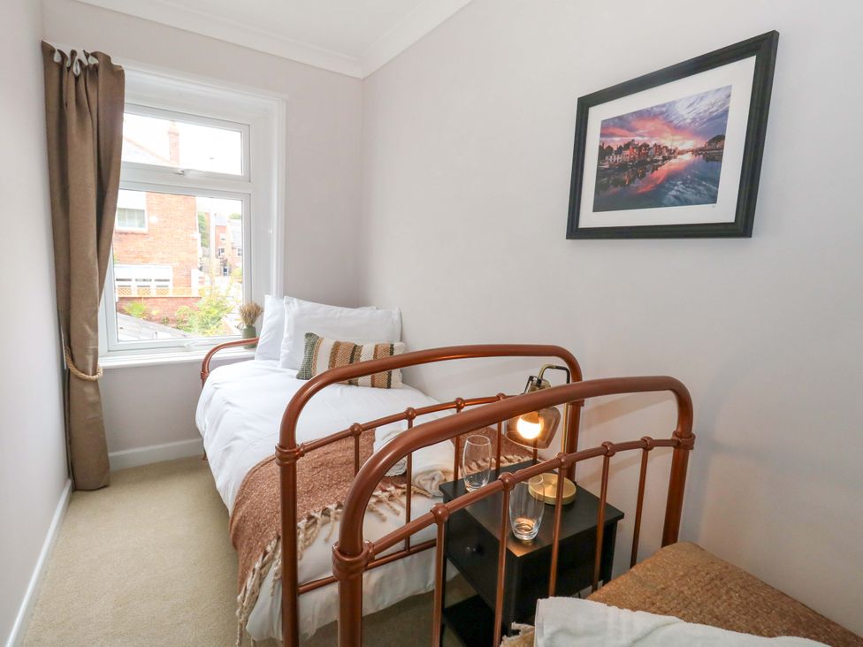 A bedroom with a bed and nightstand at Otter Cottage in Weymouth