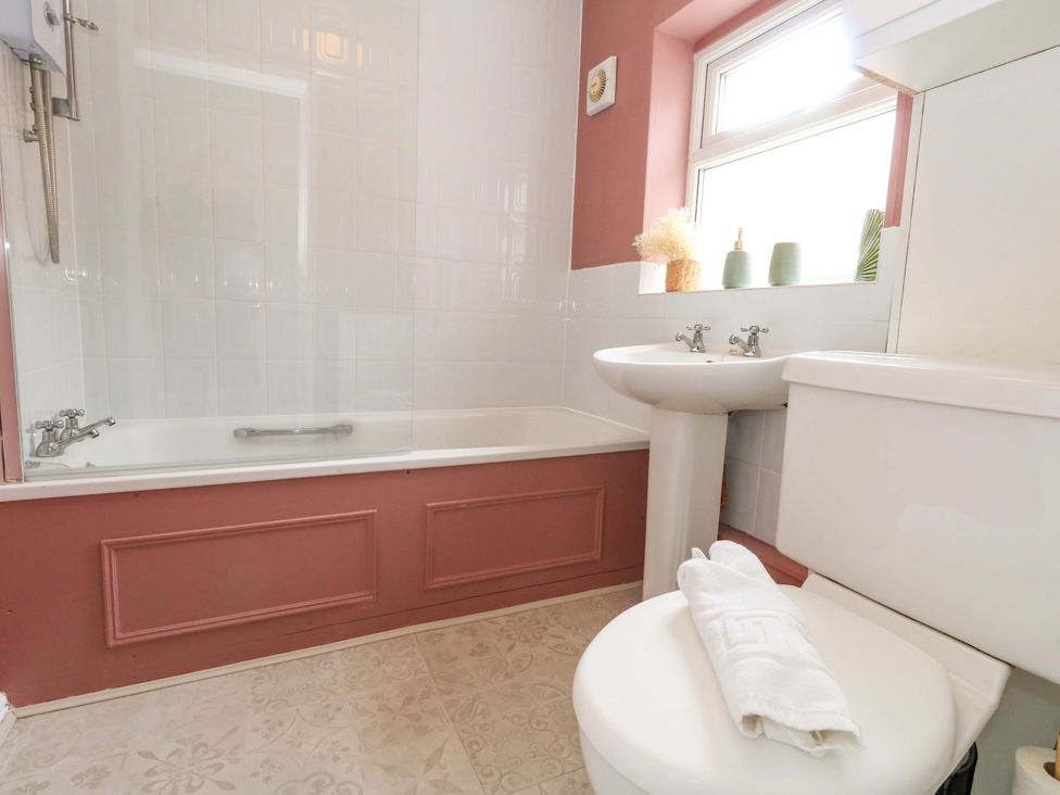 A bathroom featuring a bathtub, toilet, and sink at Otter Cottage in Weymouth