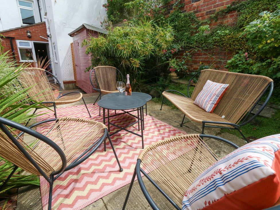 An outdoor seating area with chairs and a table at Otter Cottage in Weymouth