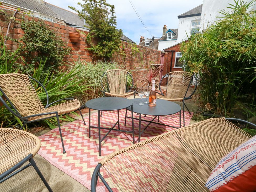 A garden with chairs and a table at Otter Cottage in Weymouth