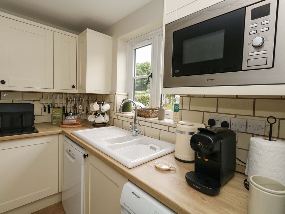 A kitchen with a sink, microwave, and coffee machine at 31 Bull Lane Dorchester