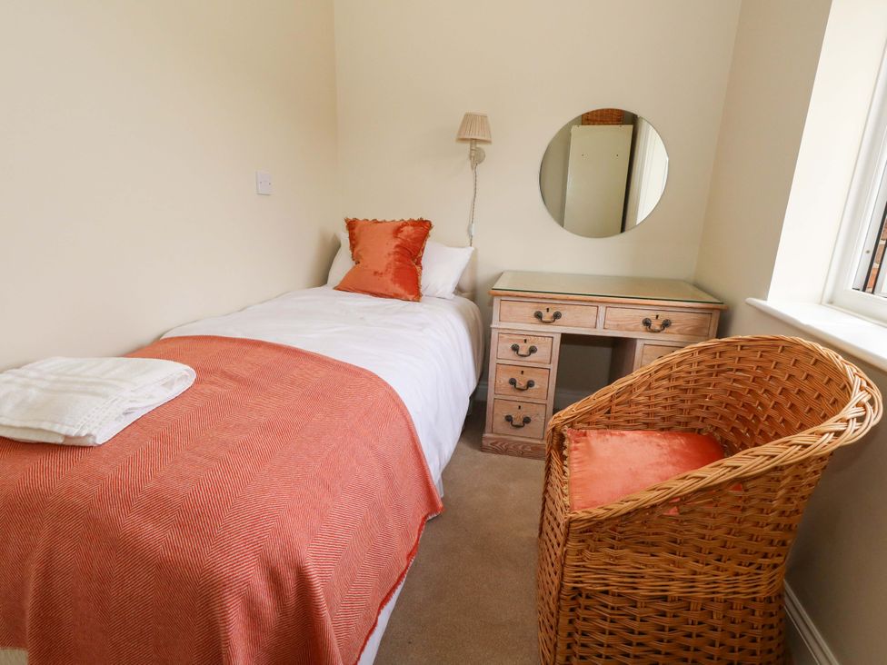 A bedroom with a bed, desk, chair and mirror at 31 Bull Lane in Dorchester