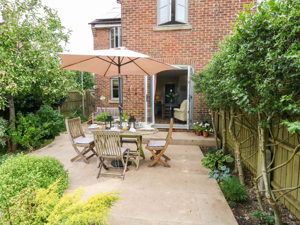 A garden with a table and chairs under an umbrella at 31 Bull Lane Dorchester