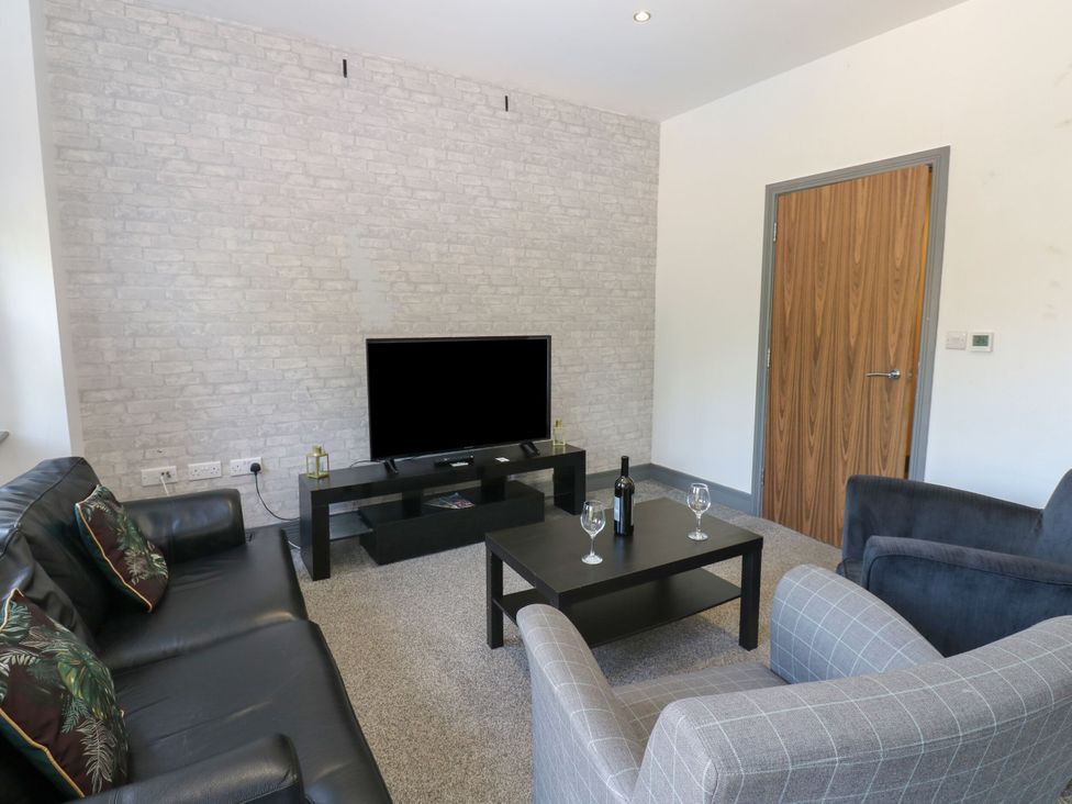 A living room with a television and seating at Quayside Apartments in Whitehaven