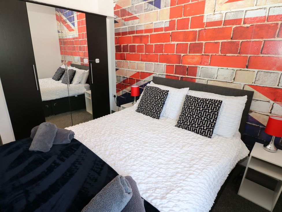 A bedroom with a bed and a mirrored wardrobe at Quayside Apartments in Whitehaven