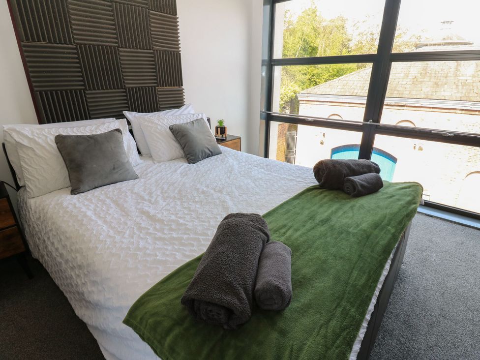 A bedroom with a bed and towels on top at Quayside Apartments in Whitehaven