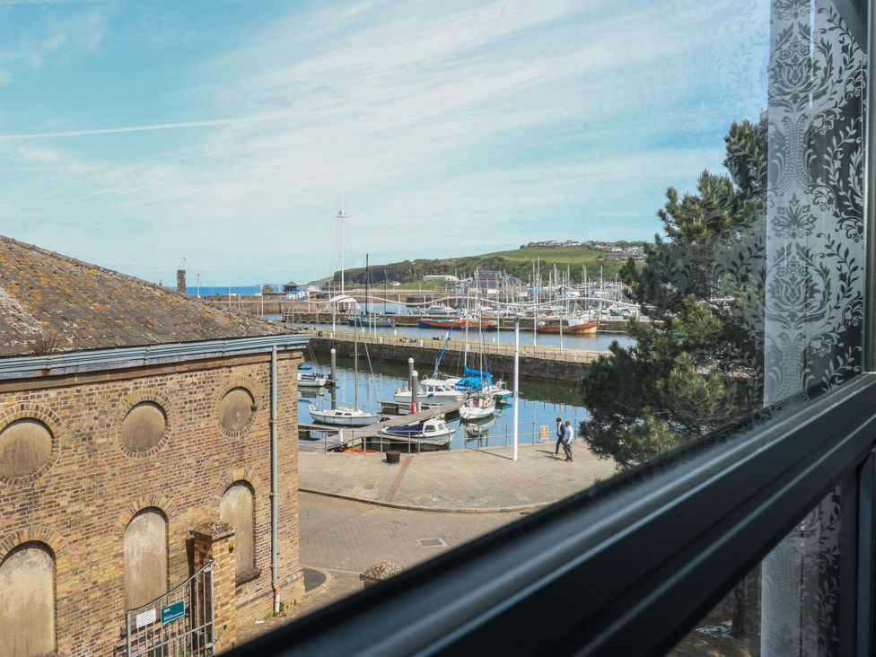 View of boats in a harbor from a window at Quayside Apartments in Whitehaven