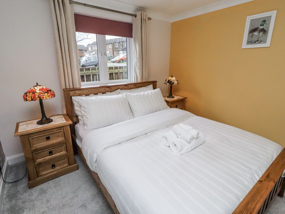 A bedroom with a bed and bedside table at 26 Blakelaw Court in Alnwick