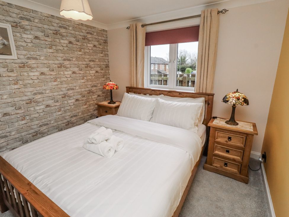 A bedroom with a bed and bedside table at 26 Blakelaw Court Alnwick