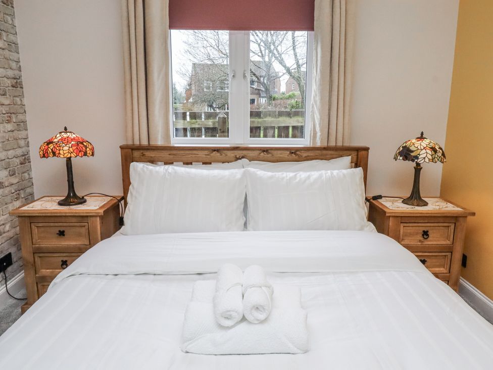 A bedroom with a bed and nightstands at 26 Blakelaw Court in Alnwick