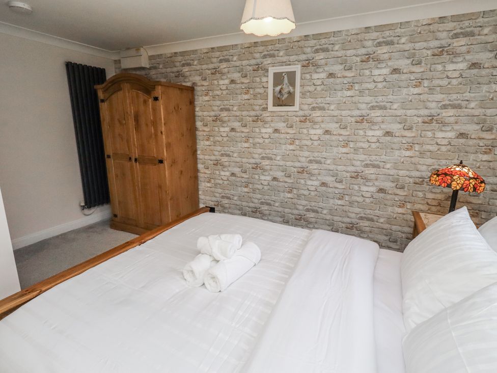 A bedroom with a bed and wardrobe at 26 Blakelaw Court in Alnwick