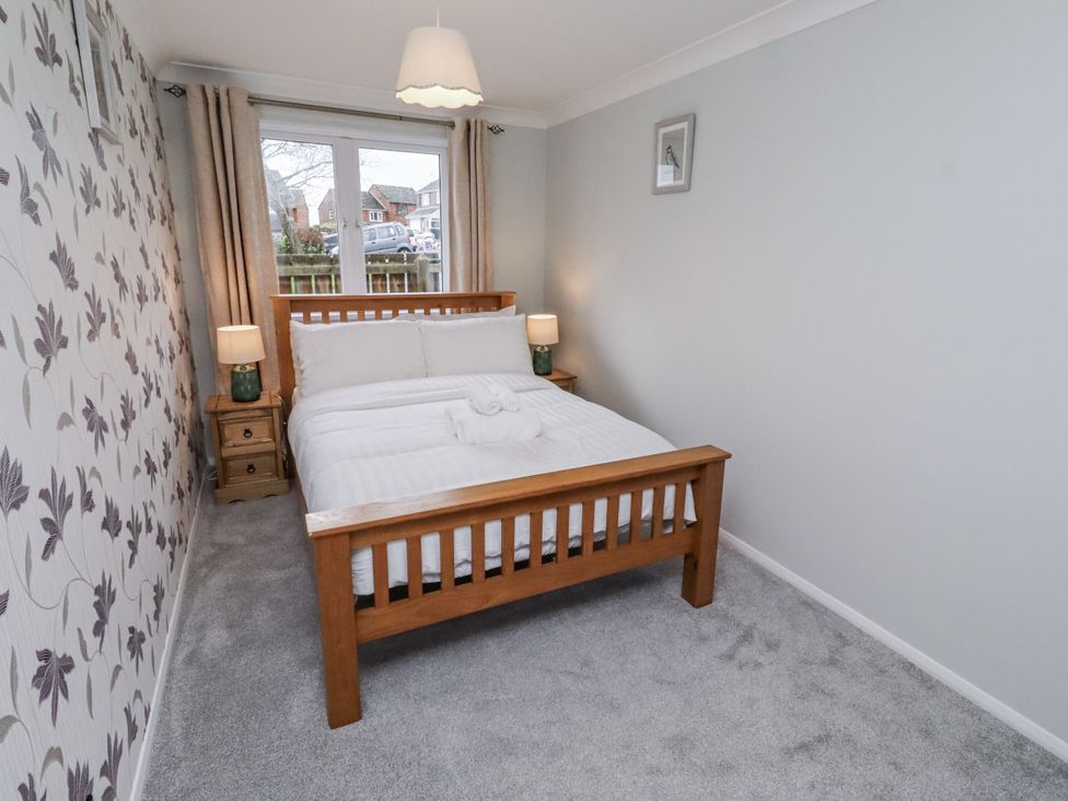 A bedroom with a bed and nightstand at 26 Blakelaw Court in Alnwick