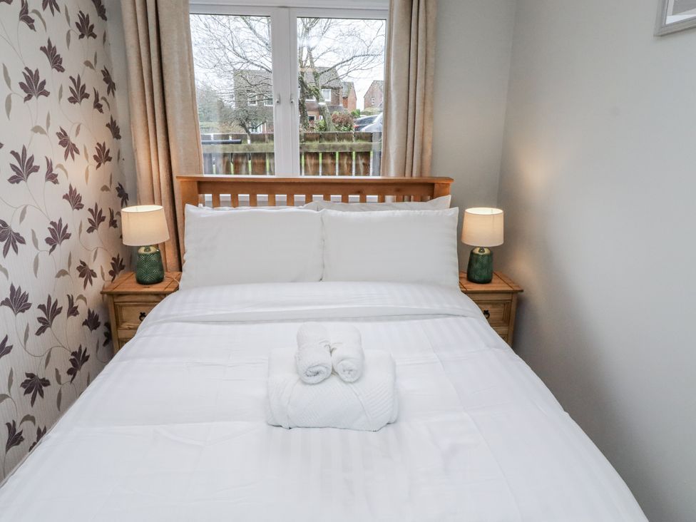 A bedroom with a bed and lamps at 26 Blakelaw Court in Alnwick