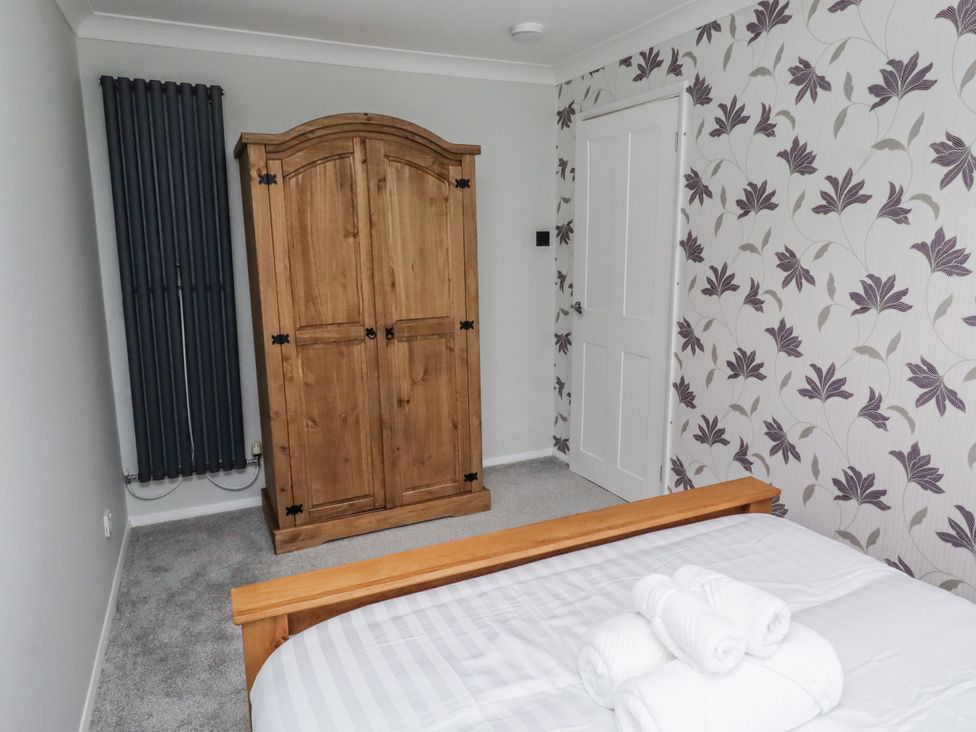 A bedroom with a bed and wardrobe at 26 Blakelaw Court in Alnwick