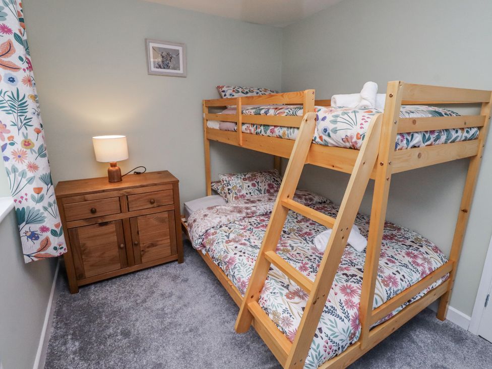 A bedroom with a bunk bed and a nightstand at 26 Blakelaw Court in Alnwick