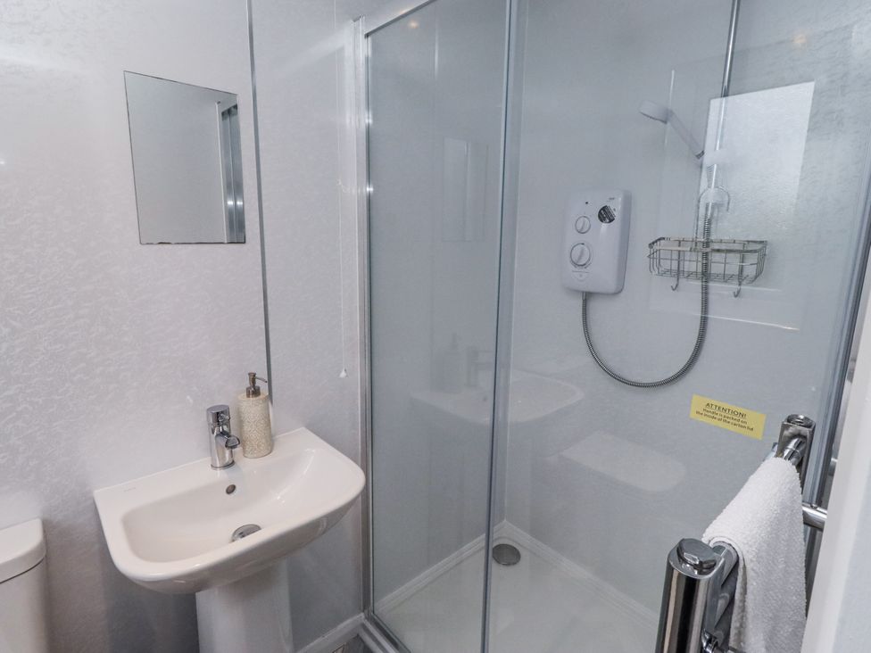 A bathroom with sink, toilet, and shower at 26 Blakelaw Court in Alnwick