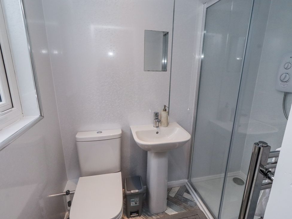 A bathroom with a shower, sink, and toilet at 26 Blakelaw Court Alnwick