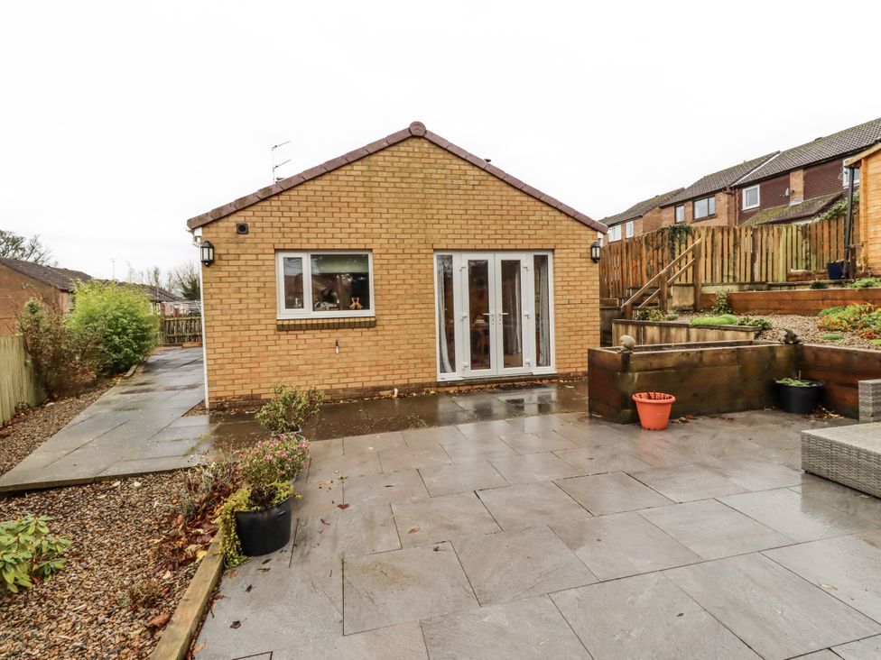 An outdoor view of a house with a patio at 26 Blakelaw Court Alnwick