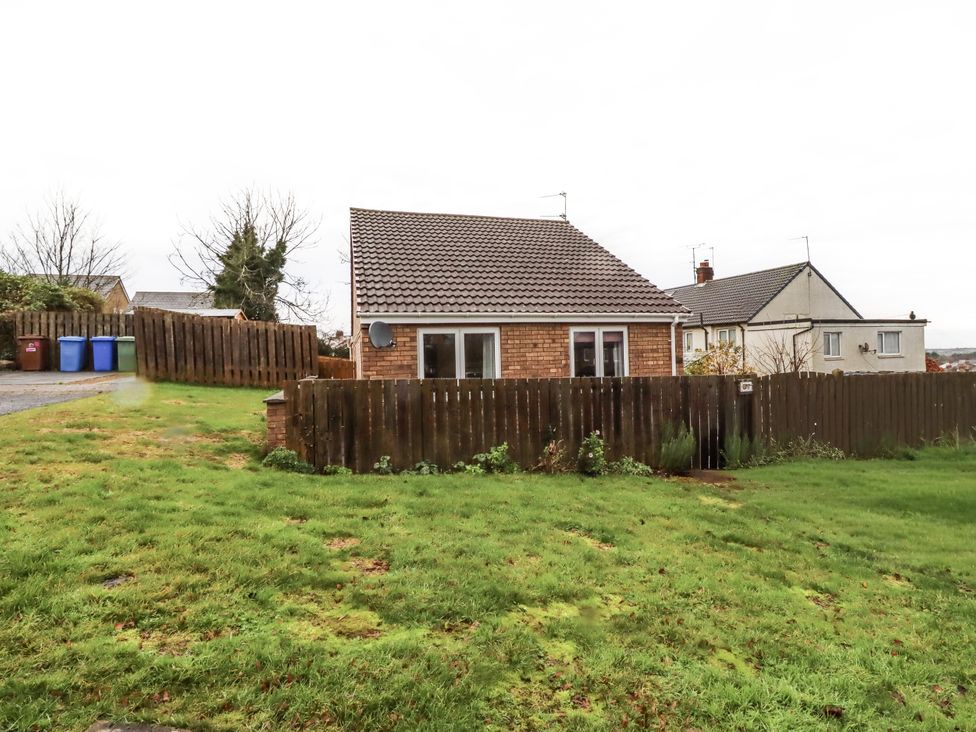A house with grass and a fence at 26 Blakelaw Court in Alnwick