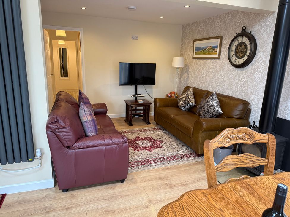 A living room with sofas and a television at Blakelaw Court in Alnwick