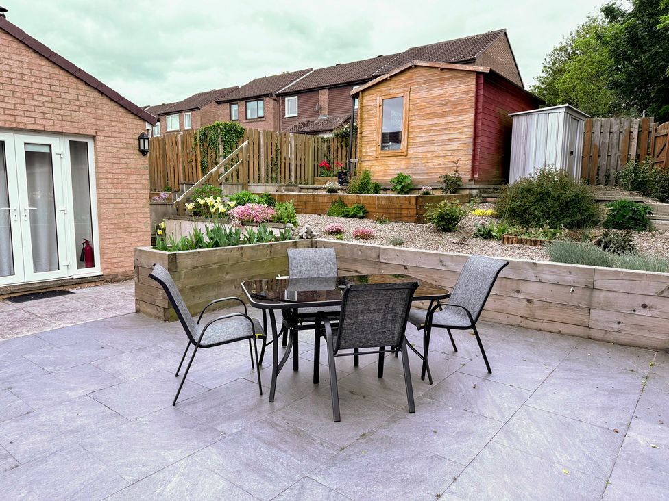 A garden with a table and chairs at Blakelaw Court in Alnwick