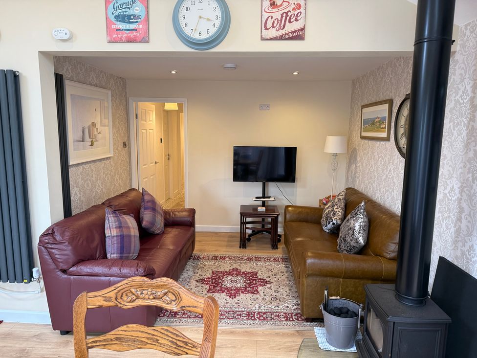 A living room with a TV and sofas at Blakelaw Court in Alnwick