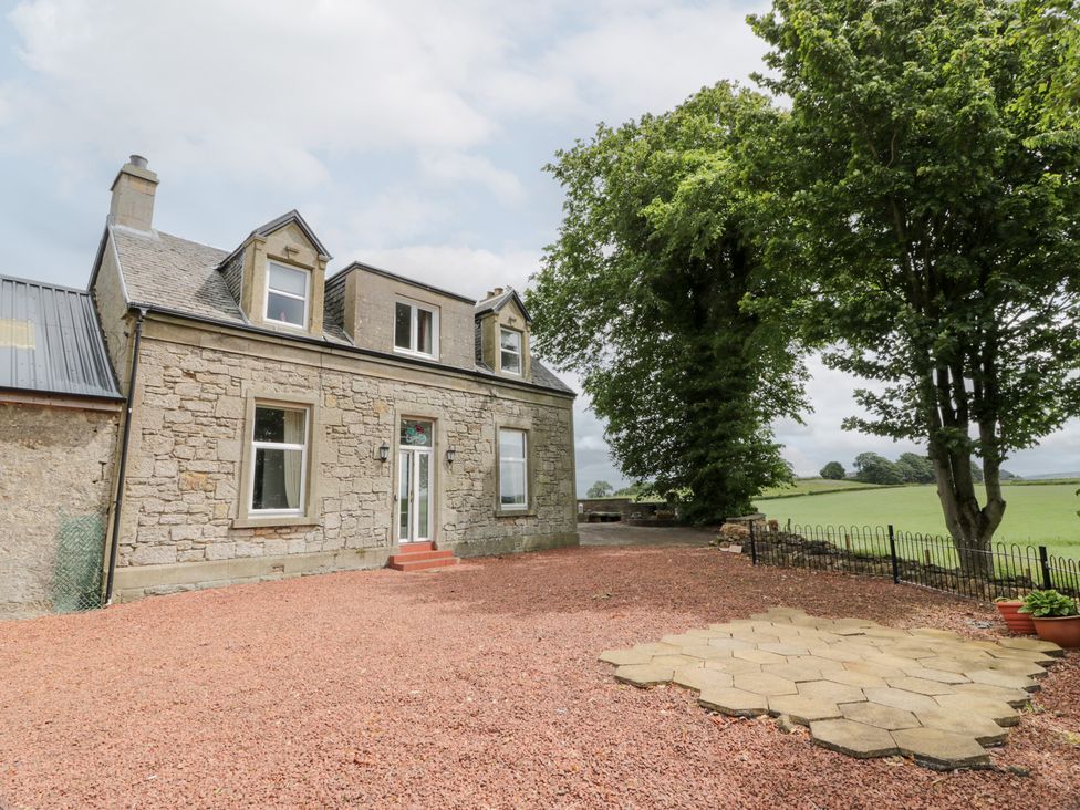 A house with stone walls and trees at Marshill Farm house Lanark