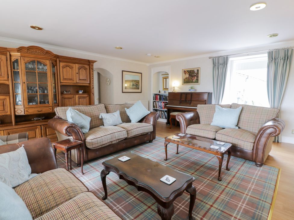 A living room with a piano and sofas at Marshill Farm house in Lanark
