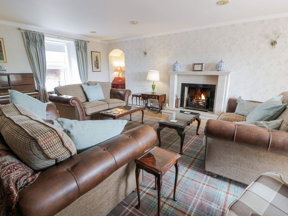 A living room with a fireplace and sofas at Marshill Farm house in Lanark