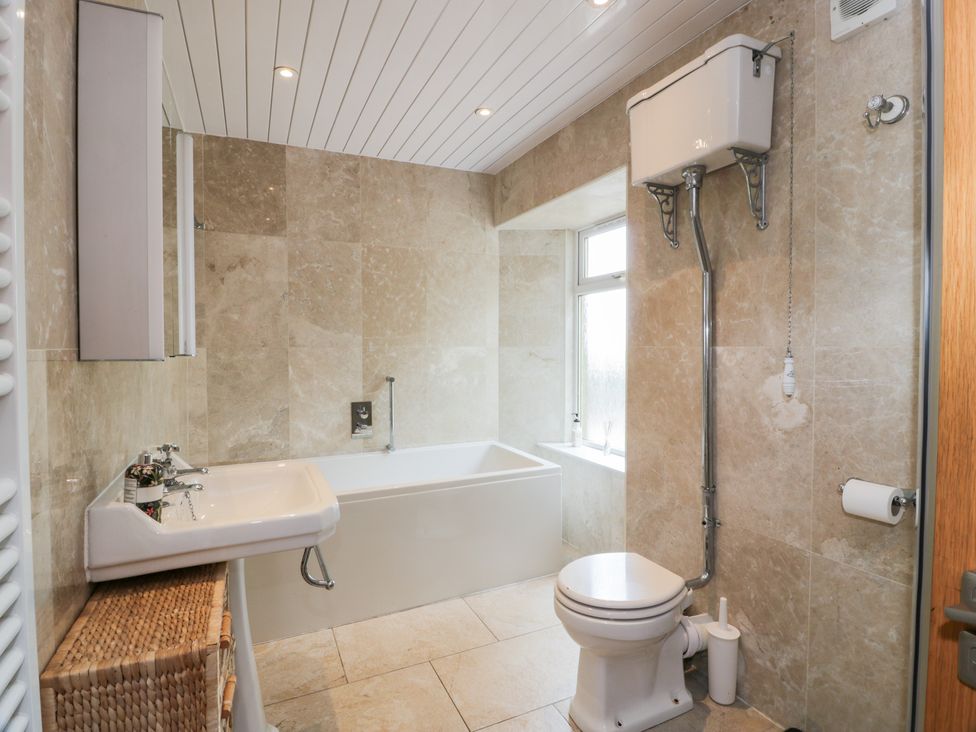 A bathroom with a bathtub and sink at Marshill Farm house in Lanark