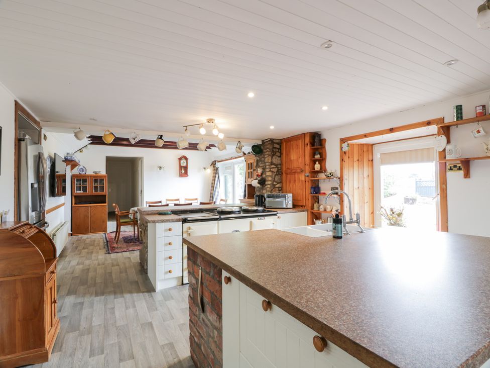 A kitchen with a central island and dining table at Marshill Farm house in Lanark