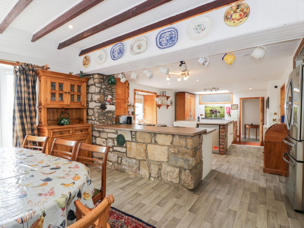 A kitchen with a dining table and cabinets at Marshill Farm house in Lanark