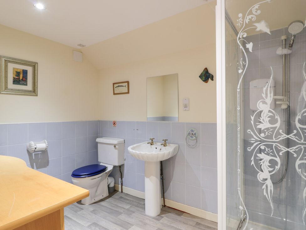 A bathroom with a toilet, sink, and shower at Marshill Farm house in Lanark