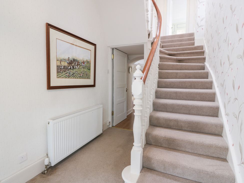 A hallway with a staircase and a framed picture at Marshill Farm house in Lanark