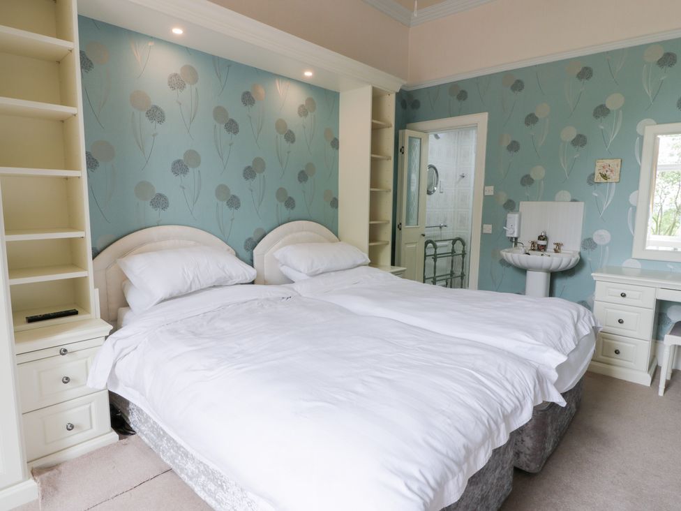 A bedroom with two beds and a sink at Marshill Farm house in Lanark