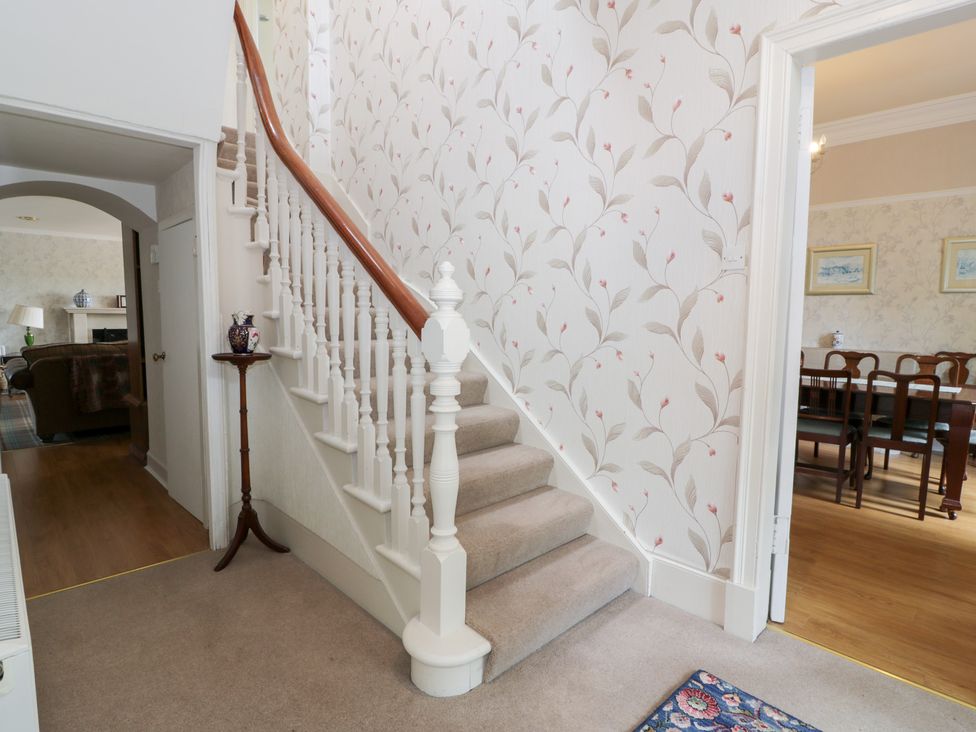 A hallway with a staircase and doorway at Marshill Farm house in Lanark