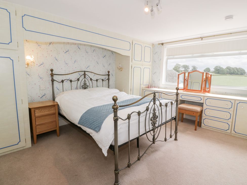 A bedroom with a bed and dressing table at Marshill Farm house in Lanark