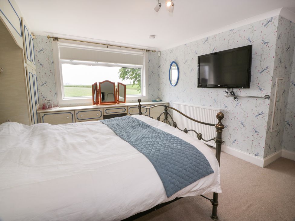 A bedroom with a bed and television at Marshill Farm house in Lanark