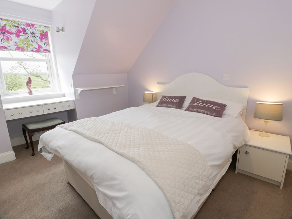 A bedroom with a bed and desk at Marshill Farm house in Lanark