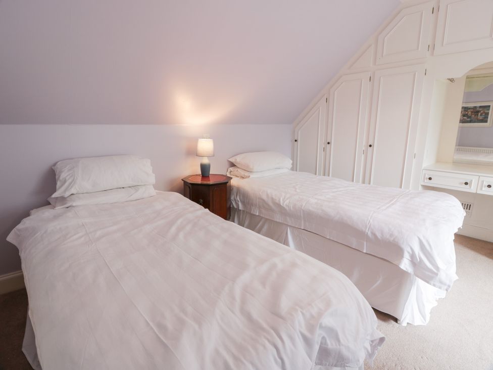A bedroom with twin beds and a lamp at Marshill Farm house Lanark