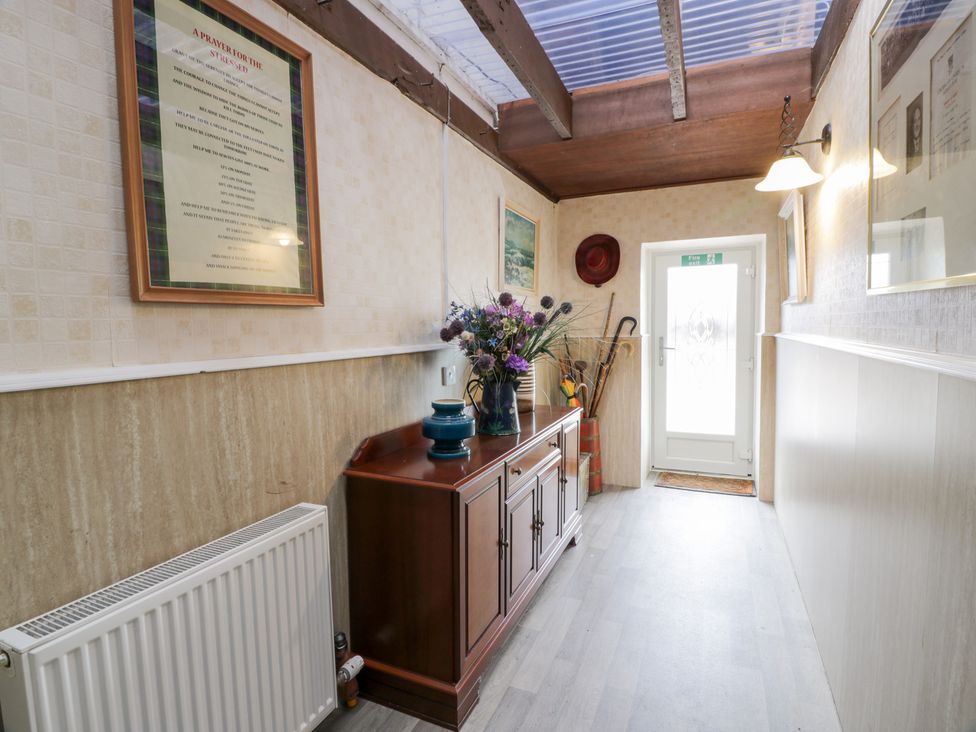 A hallway with a console table and flowers at Marshill Farm house in Lanark