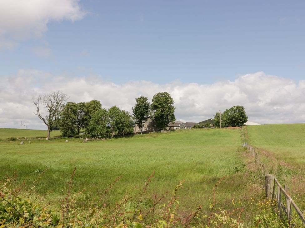A landscape with a house and trees at Marshill Farm house in Lanark