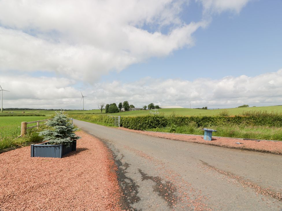 A road with grass and wind turbines at Marshill Farm house in Lanark