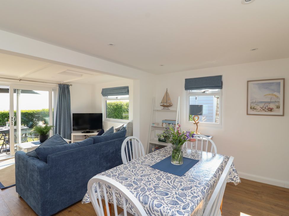 A dining area with a table and sofa at Stella Maris in Torpoint