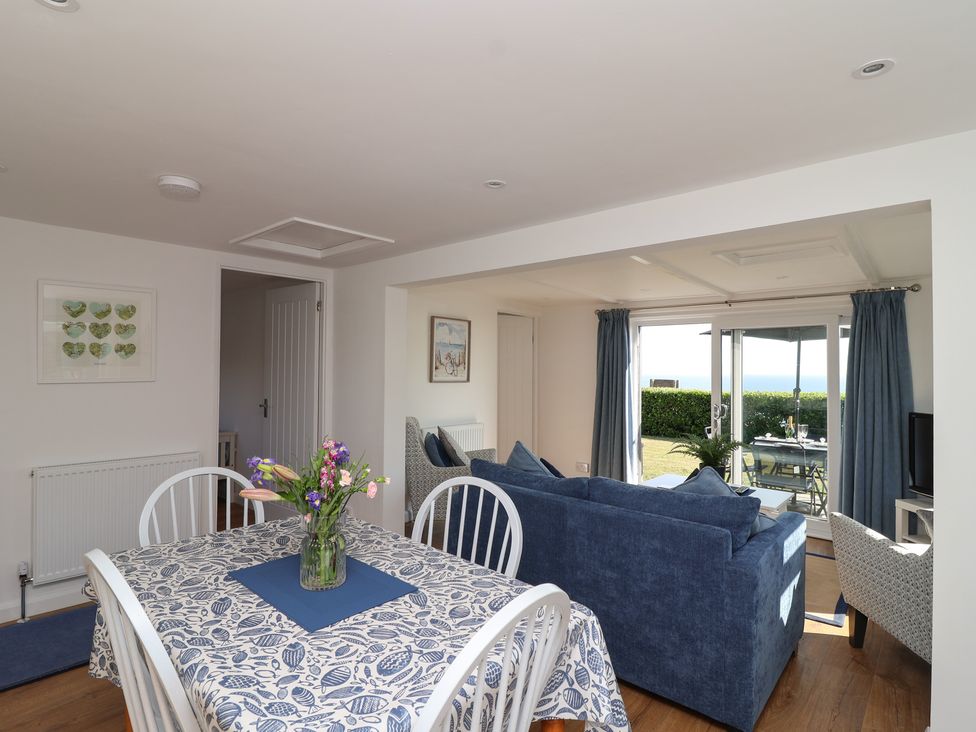 A living room with a dining area and sofa at Stella Maris in Torpoint